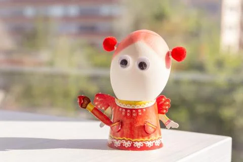 Egg for easter day. Egg is girl in the orange dress with eyes. Background close Stock-Fotos