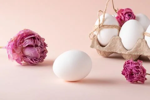 An egg with Easter eggs and eco-decor of dried roses on a beige background Foto stock