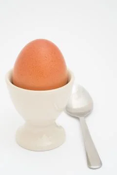 An egg in egg cup with a spoon Foto stock