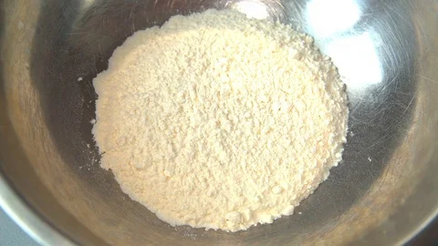 Egg falling into bowl of flour Stock Footage 72582326