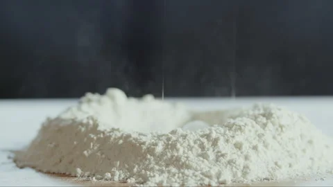 Egg falling in flour circle on a table Stock Footage 274615863