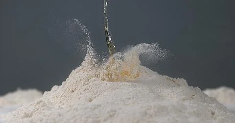Egg Falling on Flour Stock Photos