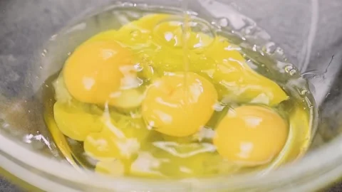 Egg falling in a glass bowl. Process of making omelet. Stock Footage 153458236