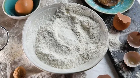 Egg falls on flour. Slow Motion Stock Footage 119212519