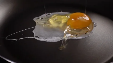 The egg falls on a hot frying pan Stock Footage