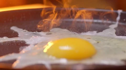 An egg falls onto a hot frying pan Stock Footage 306015648
