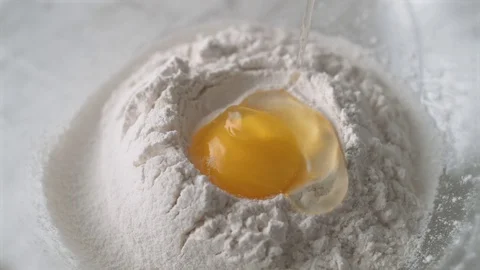 Egg falls on a pile of flour. Slow Motion. Stock Footage