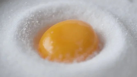 Egg falls on a pile of sugar. Slow Motion. Stock Footage 79477086