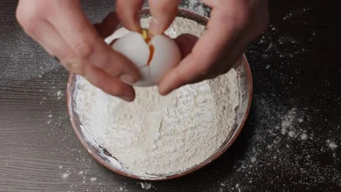 An egg falls into a plate with flour Stock Footage 264767114
