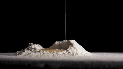 The egg falls in slow motion into flour Stock Footage 148809522