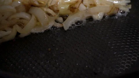 Egg falls in slow motion into a pan with fried onions. Stock Footage 126897594