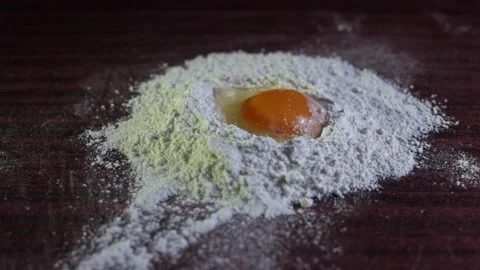 Egg in flour. Eggs fall into the flour, flour into a pile and the yolk. Stock Footage 303140430