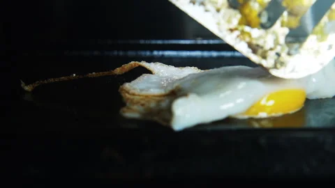 Egg fried cooked on griddle to scrambled eggs with slotted spatula 4K real a Stock Footage 246553855