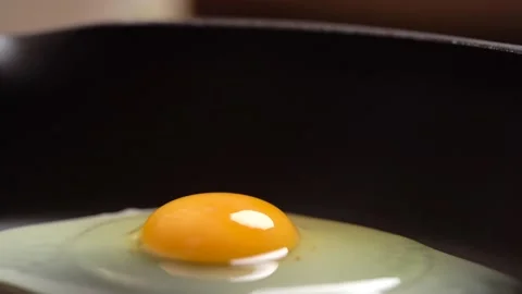 Egg is fried in a frying pan accelerated, side-view, macro. Stock Footage 156396168