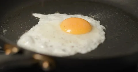 Egg fried in olive oil in super slow motion and being peppered Stock Footage 142606399