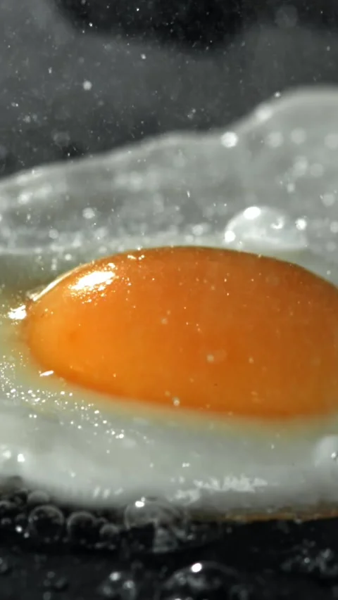 The egg is fried in a pan. Filmed on a high-speed camera at 1000 fps Stock Footage 335369341