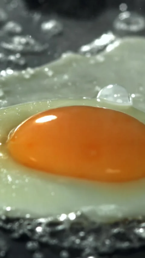 The egg is fried in a pan. Filmed on a high-speed camera at 1000 fps Stock Footage 335371494