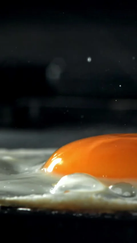 The egg is fried in a pan. Filmed on a high-speed camera at 1000 fps Stock Footage 335372206