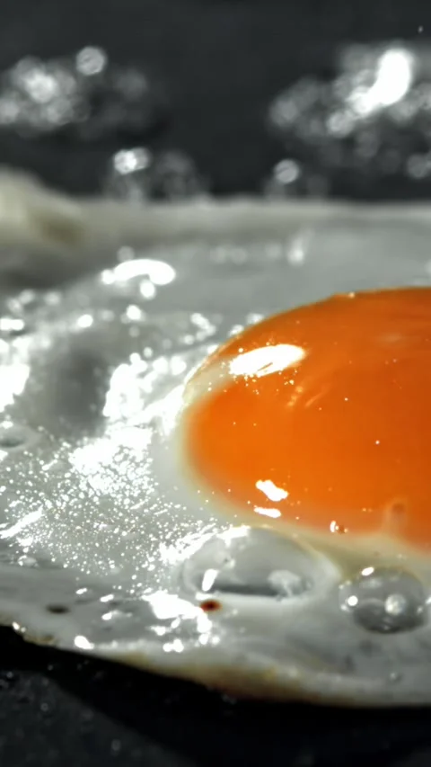 The egg is fried in a pan. Filmed on a high-speed camera at 1000 fps Stock Footage 335376057
