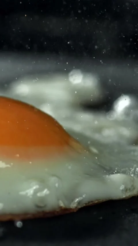 The egg is fried in a pan. Filmed on a high-speed camera at 1000 fps Stock Footage 335376274