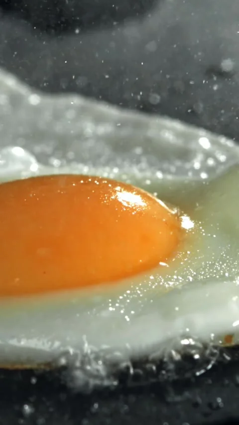 The egg is fried in a pan. Filmed on a high-speed camera at 1000 fps Stock Footage 335376494