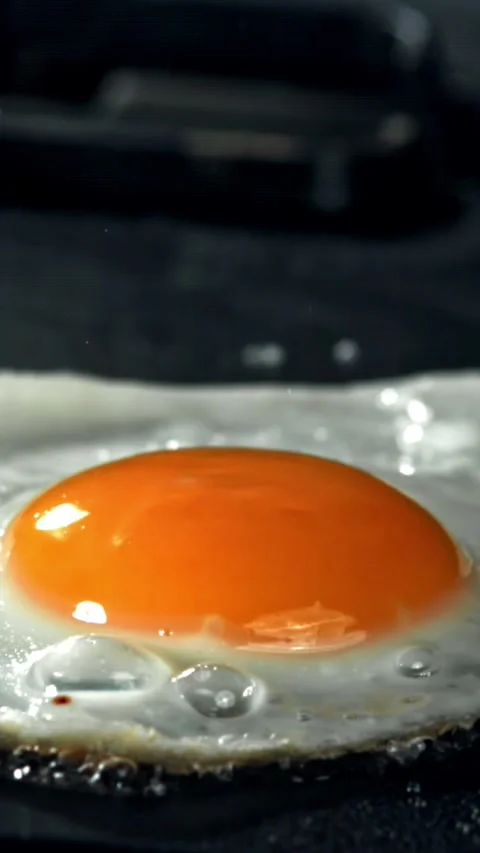 The egg is fried in a pan. Filmed on a high-speed camera at 1000 fps Stock Footage 335381172