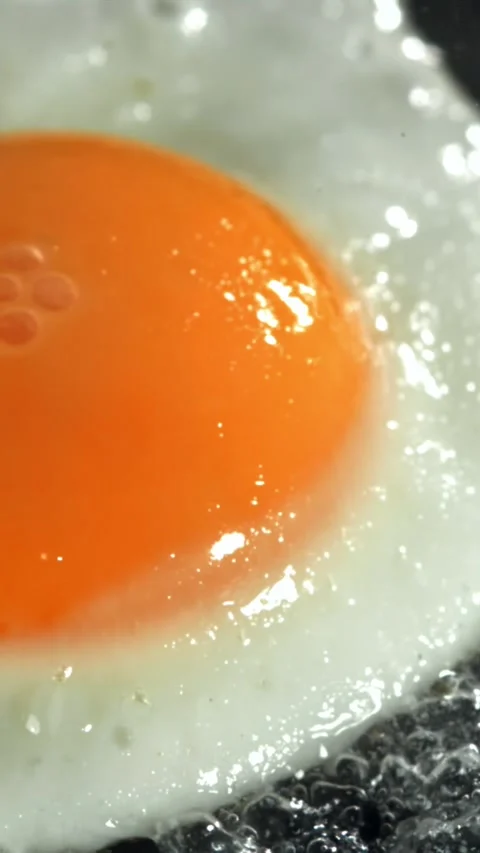 The egg is fried in a pan. Filmed on a high-speed camera at 1000 fps Stock Footage 335384298