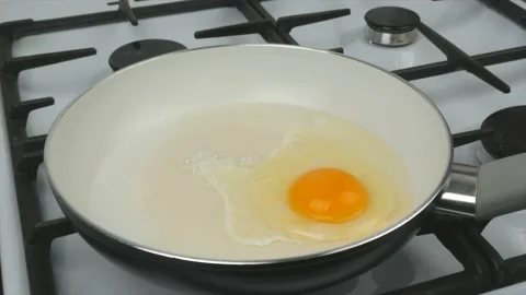 Egg fried in a pan with a white non-stick coating - quick breakfast Stock Footage 134309556
