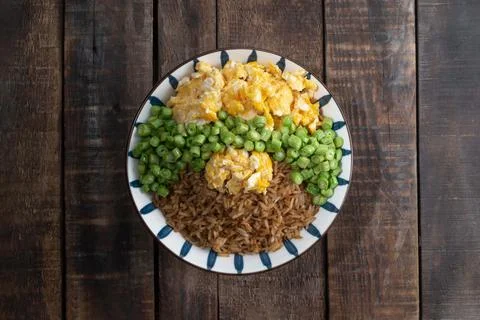 Egg fried rice and bean in bowl on wood table. Stock Photos