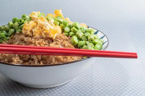 Egg fried rice and bean in bowl on white table. Stock Photos