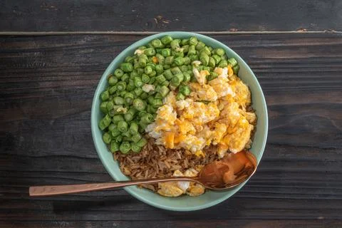 Egg fried rice and bean in green bowl on wood table. Stock Photos