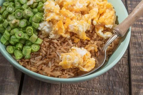 Egg fried rice and bean in green bowl on wood table. Stock Photos