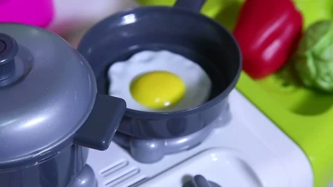 Egg is fried in a toy plastic frying pan. Stock Footage 100178280