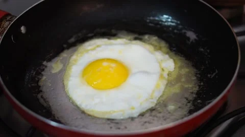 Egg frying in a frying pan with melted butter. Stock Footage 141963837
