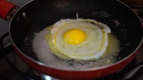 Egg frying in a frying pan with melted butter. Stock Footage 141964604