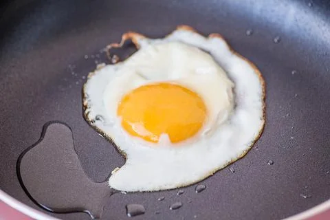 Egg on the frying pan - close up Stock Photos