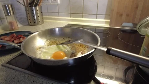 An egg frying in a stainless steel pan Stock Footage 230618112