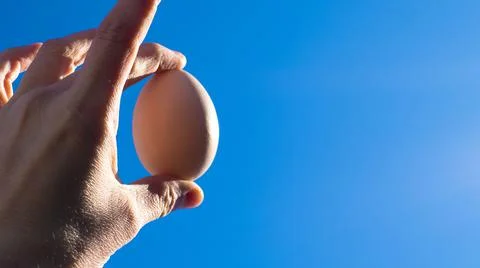 Egg in hand against the sky. easter Stock Photos