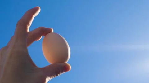Egg in hand against the sky. easter Stock Photos