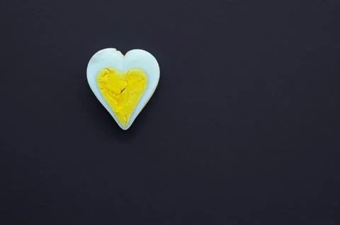 Egg heart shape on black background Stock Photos