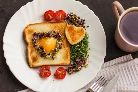 Egg in a hole of bread heart shape, microgreens, healthy food Breakfast, tea, Stock Photos