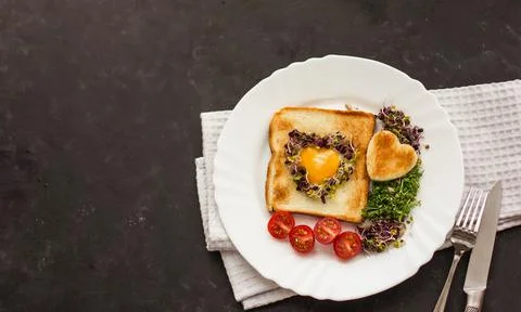 Egg in a hole of bread heart shape, microgreens, healthy food Breakfast, tea, Stock Photos