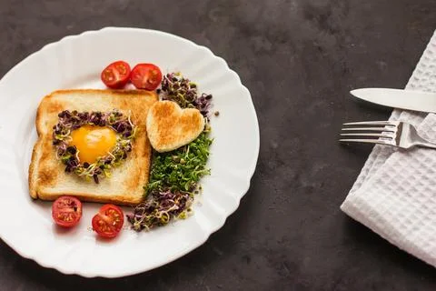 Egg in a hole of bread heart shape, microgreens, healthy food Breakfast, tea, Stock Photos
