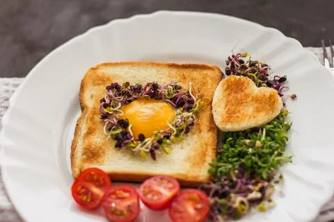 Egg in a hole of bread heart shape, microgreens, healthy food Breakfast, tea, Stock Photos