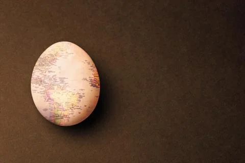 Egg with map texture on brown background. Stock Photos