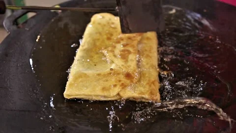 Egg martabak filled with meat is being fried and doused in hot oil Stock Footage 272298223