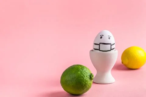 Egg in mask in an egg stand, lime and lemon. concept of Easter, vitamins, health Stock Photos