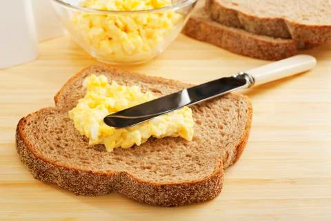 Egg mayonnaise being spread on bread Stock Photos