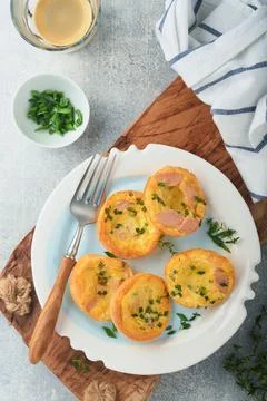 Egg muffins with green onions, bacon, cheese and tomatoes on white plate on l Stock Photos