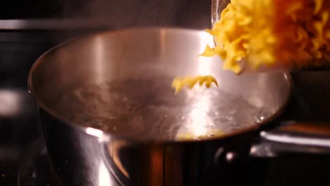 Egg noodles falling in slow motion into boiling water close up Stock Footage 150990348
